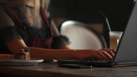 Mujer-Joven-Con-Reloj-Inteligente-Usando-Una-Computadora-Portátil.-Mujer-Trabajando-En-Una-Computadora-Portátil-En-Un-Café-Al-Aire-Libre.
